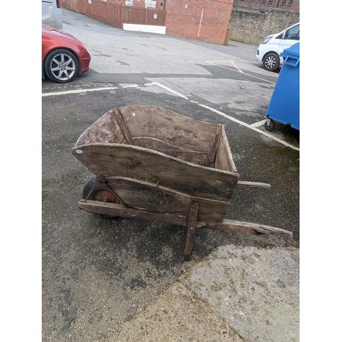 652 - A weathered decorative large wooden garden Wheelbarrow, note lots of wear, W 77 cm x H 89 cm x D 155... 