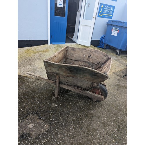 652 - A weathered decorative large wooden garden Wheelbarrow, note lots of wear, W 77 cm x H 89 cm x D 155... 