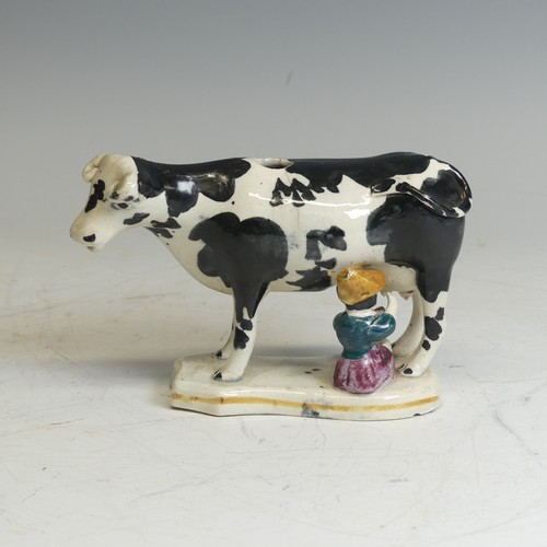 106 - An antique Staffordshire Cow Creamer, modelled as being milked, lacks cover, damaged, H 13cm, togeth... 