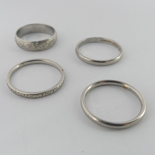 284 - A textured platinum Band, Size L, together with three other narrown platinum bands, two size O, the ... 