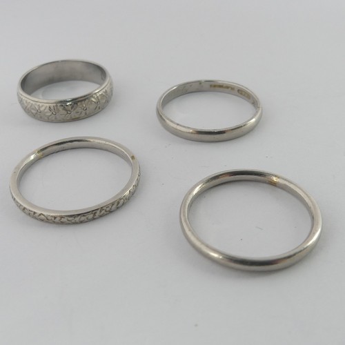 284 - A textured platinum Band, Size L, together with three other narrown platinum bands, two size O, the ... 