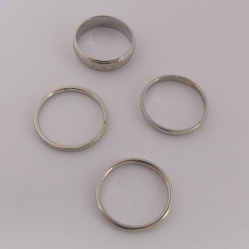 284 - A textured platinum Band, Size L, together with three other narrown platinum bands, two size O, the ... 