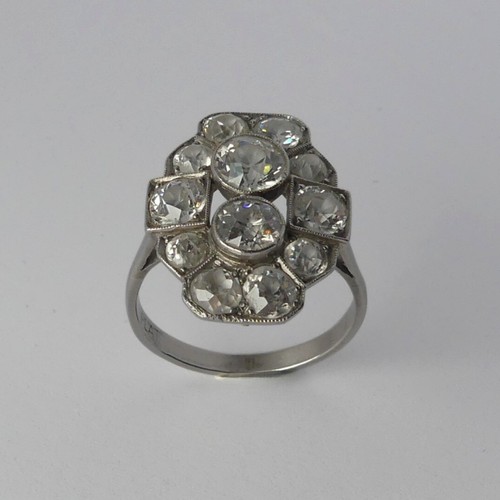 282 - An Art Deco diamond Cluster Ring, the old cut stones millegrain set in platinum on a plain shank, th... 