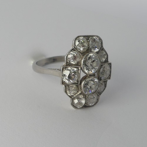 282 - An Art Deco diamond Cluster Ring, the old cut stones millegrain set in platinum on a plain shank, th... 