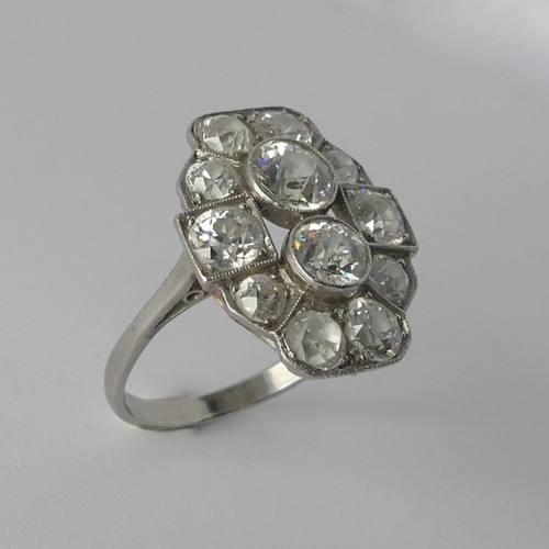 282 - An Art Deco diamond Cluster Ring, the old cut stones millegrain set in platinum on a plain shank, th... 