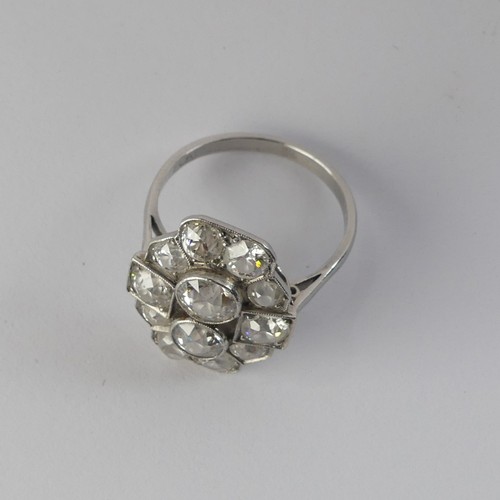 282 - An Art Deco diamond Cluster Ring, the old cut stones millegrain set in platinum on a plain shank, th... 