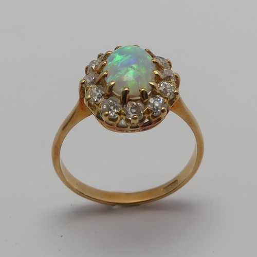 274 - An opal and diamond cluster Ring, the central oval cabochon opal, approx. 8.8mm long, claw set withi... 