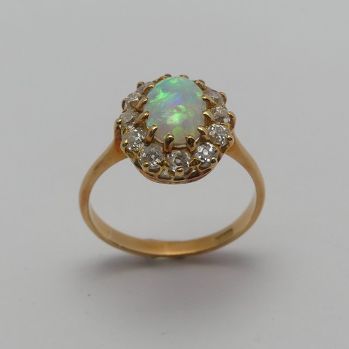 274 - An opal and diamond cluster Ring, the central oval cabochon opal, approx. 8.8mm long, claw set withi... 