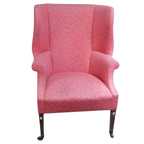 510 - An antique wing-back Armchair, upholstered in pink, raised on tapering front legs with castors and r... 