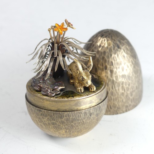 Stuart Devlin; A silver gilt 'Surprise Egg', hallmarked London 1981, the textured egg opening to reveal a rabbit amongst foliage on a green enamel ground, 6.5cm high, total weight 106g, no box or certificate.