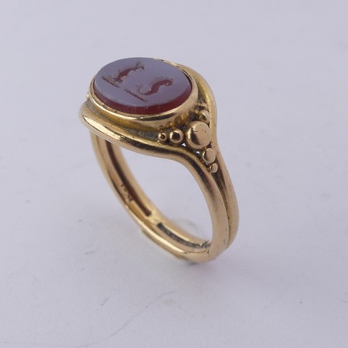 247 - An 18ct yellow gold Signet Ring, the front set with an oval carnelian, carved with two mythical beas... 