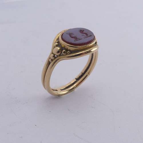 247 - An 18ct yellow gold Signet Ring, the front set with an oval carnelian, carved with two mythical beas... 