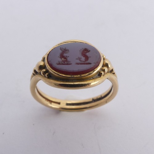 247 - An 18ct yellow gold Signet Ring, the front set with an oval carnelian, carved with two mythical beas... 