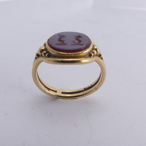 247 - An 18ct yellow gold Signet Ring, the front set with an oval carnelian, carved with two mythical beas... 