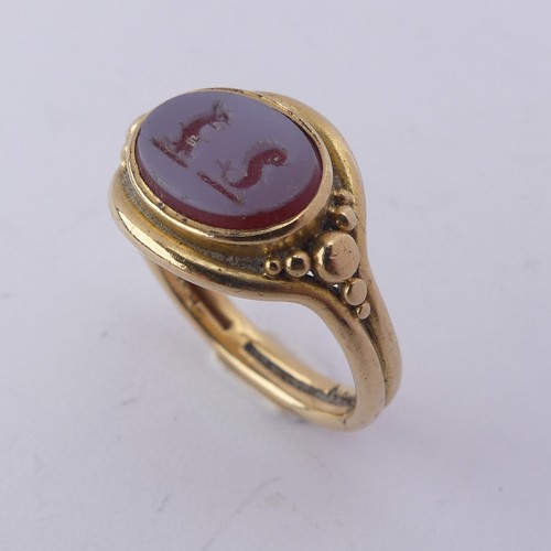 247 - An 18ct yellow gold Signet Ring, the front set with an oval carnelian, carved with two mythical beas... 