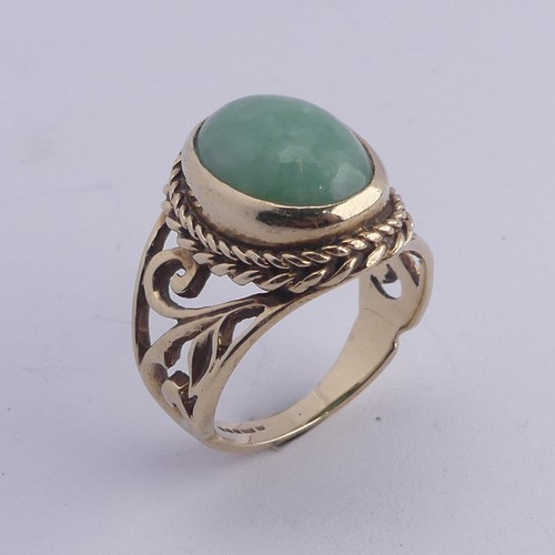 257 - A jade Dress Ring, the oval cabochon stone approx. 13mm long, collet set in ropetwist mount with scr... 