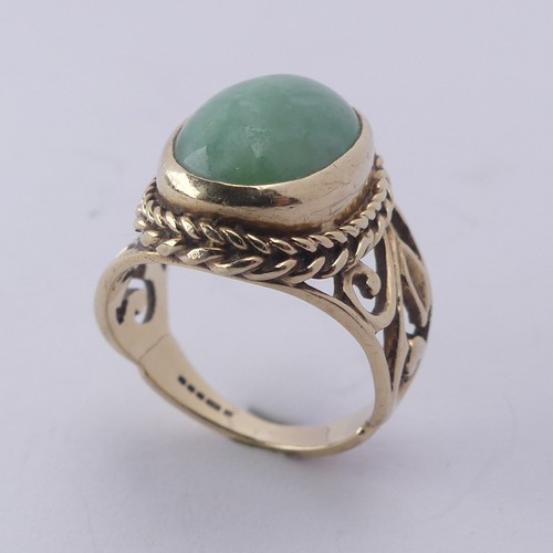 257 - A jade Dress Ring, the oval cabochon stone approx. 13mm long, collet set in ropetwist mount with scr... 