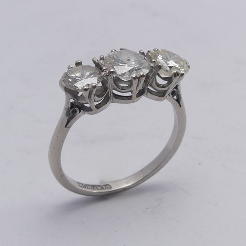 A three stone diamond Ring, the centre stone approx. 0.8ct, with a smaller stone on either side, one approx. 0.62ct, the other 0.55, claw set in platinum, Size N, total weight 4.1g.