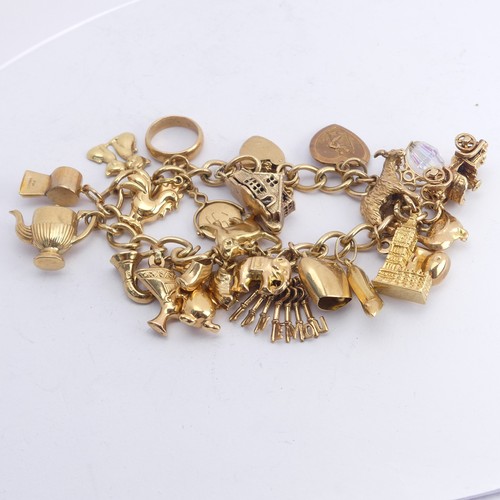 323 - A 9ct yellow gold curb link Bracelet, with 9ct gold padlock clasp, with twenty three charms suspende... 