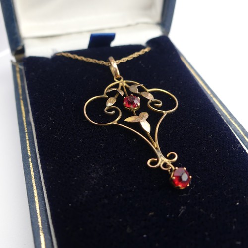 411 - A 9ct gold Art Nouveau Pendant, set two red facetted pastes, 4cm long, on 9ct gold trace chain toget... 