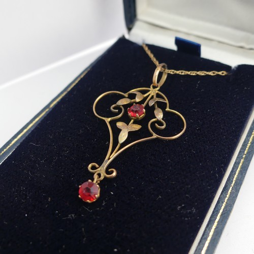 411 - A 9ct gold Art Nouveau Pendant, set two red facetted pastes, 4cm long, on 9ct gold trace chain toget... 