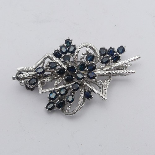 348 - A sapphire and diamond Brooch, formed with twenty-nine oval facetted sapphires with diamond point ac... 