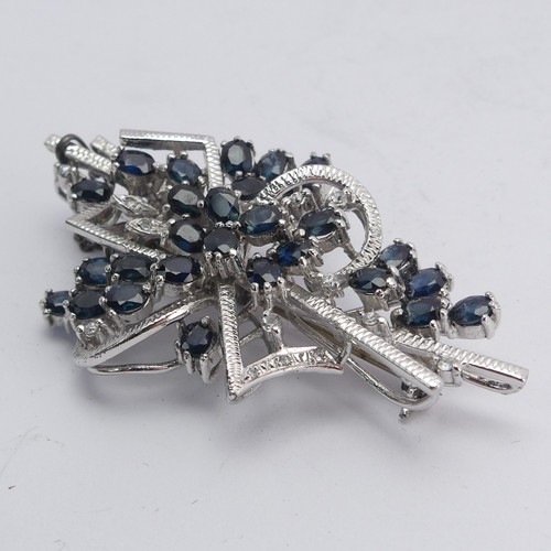 348 - A sapphire and diamond Brooch, formed with twenty-nine oval facetted sapphires with diamond point ac... 