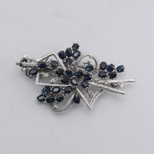 348 - A sapphire and diamond Brooch, formed with twenty-nine oval facetted sapphires with diamond point ac... 