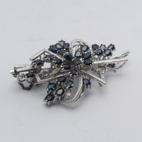 348 - A sapphire and diamond Brooch, formed with twenty-nine oval facetted sapphires with diamond point ac... 