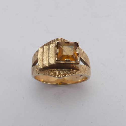 270 - A 1970's style 9ct gold and citrine Ring, the square facetted stone in offset textured mount with sp... 