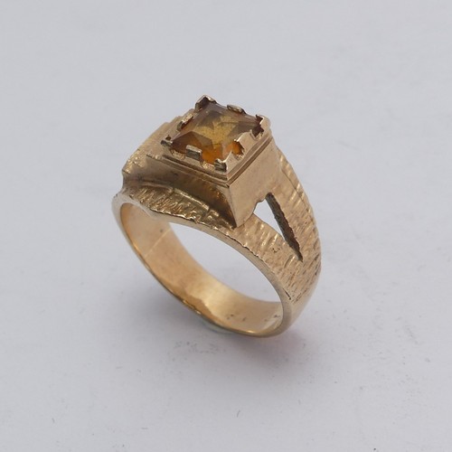 270 - A 1970's style 9ct gold and citrine Ring, the square facetted stone in offset textured mount with sp... 