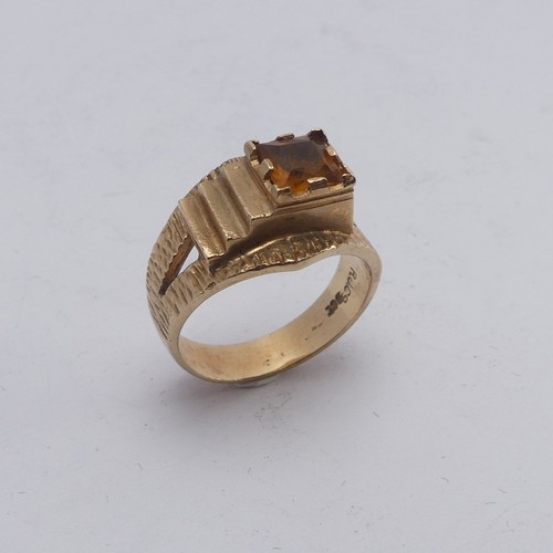 270 - A 1970's style 9ct gold and citrine Ring, the square facetted stone in offset textured mount with sp... 