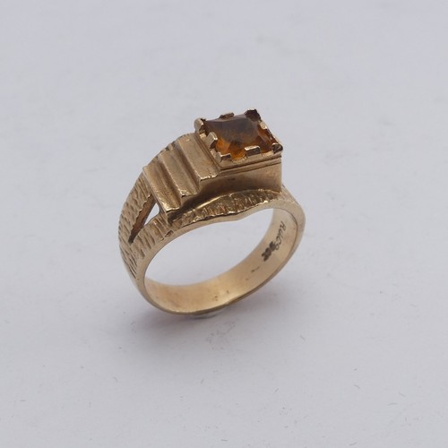 270 - A 1970's style 9ct gold and citrine Ring, the square facetted stone in offset textured mount with sp... 