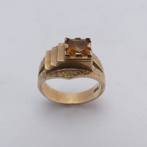 270 - A 1970's style 9ct gold and citrine Ring, the square facetted stone in offset textured mount with sp... 