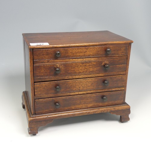 492 - An antique oak miniature tabletop Chest of drawers, rectangular top over four long graduating drawer... 