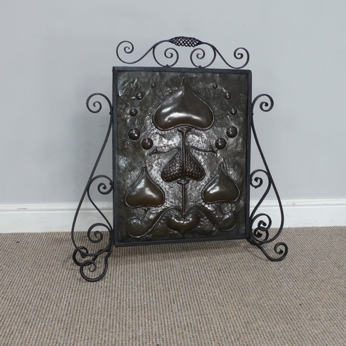 645 - An Art Nouveau copper Firescreen, embossed with stylised hearts and foliage, framed in scrolled wrou... 