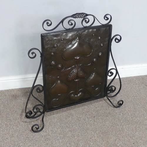 645 - An Art Nouveau copper Firescreen, embossed with stylised hearts and foliage, framed in scrolled wrou... 