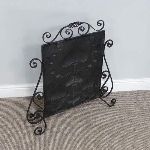 645 - An Art Nouveau copper Firescreen, embossed with stylised hearts and foliage, framed in scrolled wrou... 