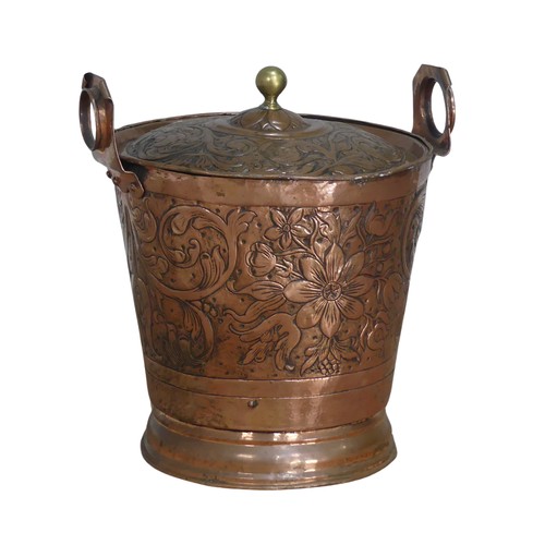 602 - An Arts and Crafts hammered copper Bucket, embossed with Art Nouveau inspired stylised flowers and l... 