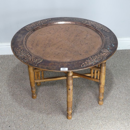 626 - A large Arts and Crafts copper tray Table, outer rim embossed with stylised flowers, with folding st... 