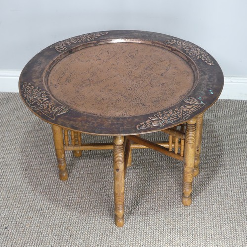 626 - A large Arts and Crafts copper tray Table, outer rim embossed with stylised flowers, with folding st... 