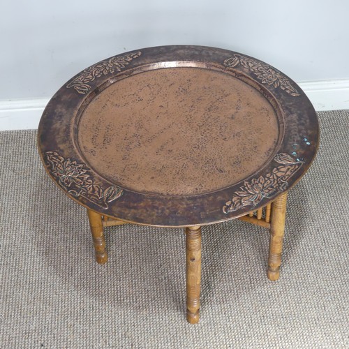 626 - A large Arts and Crafts copper tray Table, outer rim embossed with stylised flowers, with folding st... 