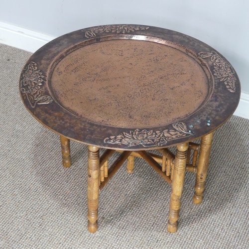 626 - A large Arts and Crafts copper tray Table, outer rim embossed with stylised flowers, with folding st... 