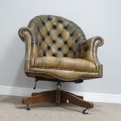 570 - A deep button-back leather swivel desk Chair, scroll arms above serpentine front seat, raised on cas... 