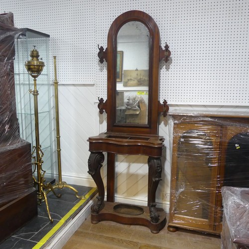 562 - A Victorian mahogany serpentine front Hall Stand, of narrow proportions, arched mirror flanked by tw... 