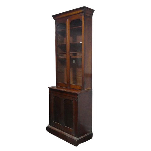 555 - A Victorian mahogany glazed Bookcase of narrow proportions, moulded cornice above two glazed cupboar... 