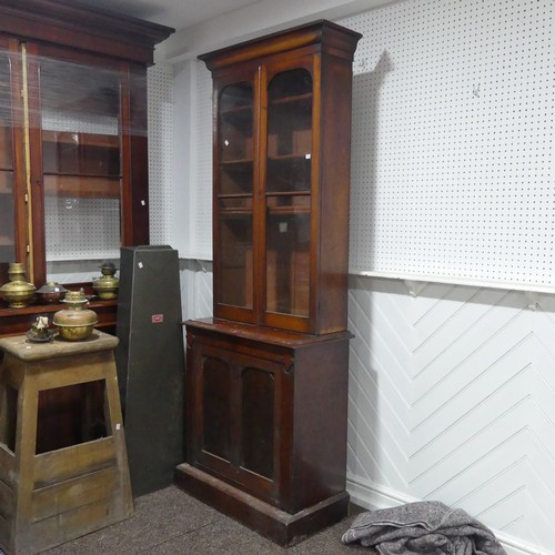 555 - A Victorian mahogany glazed Bookcase of narrow proportions, moulded cornice above two glazed cupboar... 