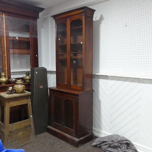 555 - A Victorian mahogany glazed Bookcase of narrow proportions, moulded cornice above two glazed cupboar... 