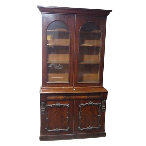 678 - A Victorian mahogany glazed Bookcase, moulded cornice over arched glazed doors, raised on cupboard b... 