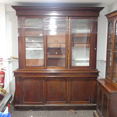 554 - A large Victorian mahogany glazed Bookcase, overhanging moulded cornice above three large glazed cup... 